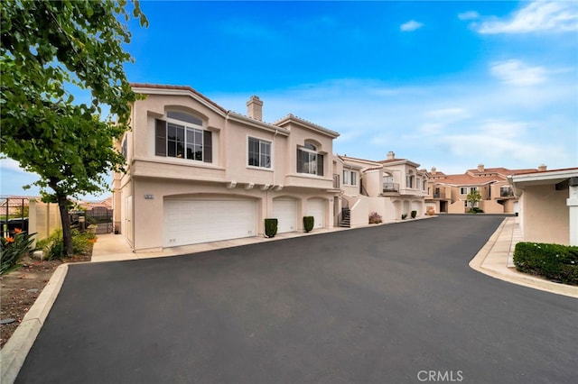 28747 La Triana, Laguna Niguel, CA 92677 - view of front of home with a chimney, a residential view, stucco siding, a garage, and a tiled roof