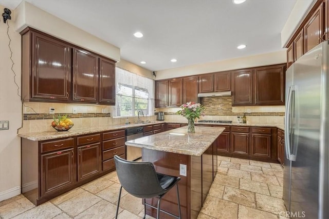 12614 Torrey Pine Rd, Moreno Valley, CA 92555 - kitchen with appliances with stainless steel finishes, stone tile floors, a sink, light stone counters, and decorative backsplash