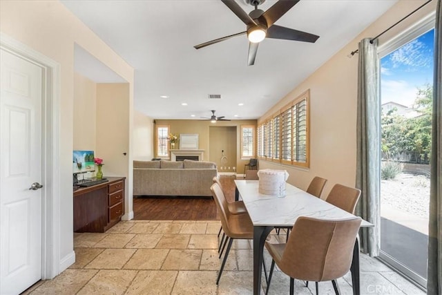 12614 Torrey Pine Rd, Moreno Valley, CA 92555 - dining space with ceiling fan, a fireplace, stone tile floors, and recessed lighting