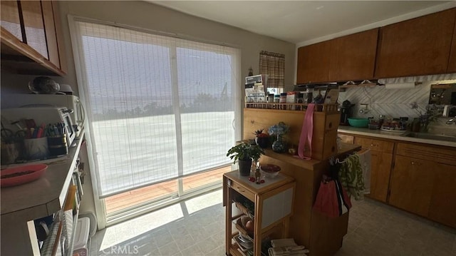 3788 Lakeview Ter, Lucerne, CA 95458 - kitchen featuring a sink, backsplash, brown cabinets, and tile patterned floors
