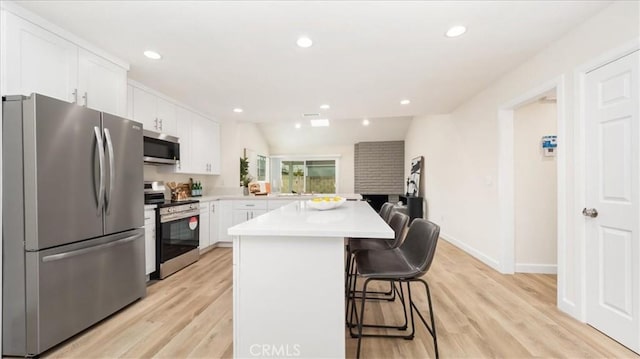 19029 Pires Ave, Cerritos, CA 90703 - kitchen with stainless steel appliances, a breakfast bar area, light countertops, white cabinetry, and a kitchen island