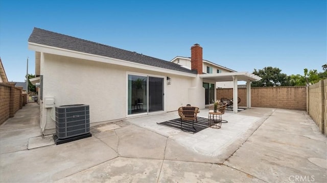 19029 Pires Ave, Cerritos, CA 90703 - rear view of property featuring central AC, stucco siding, a fenced backyard, a patio area, and a chimney