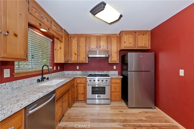 23819 Scenic Dr, Crestline, CA 92325 - kitchen featuring stainless steel appliances, under cabinet range hood, a sink, light stone countertops, and light wood-style floors