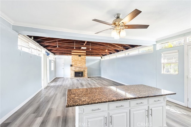 9232 S 7th Ave, Inglewood, CA 90305 - kitchen featuring baseboards, a ceiling fan, white cabinetry, dark stone countertops, and a center island