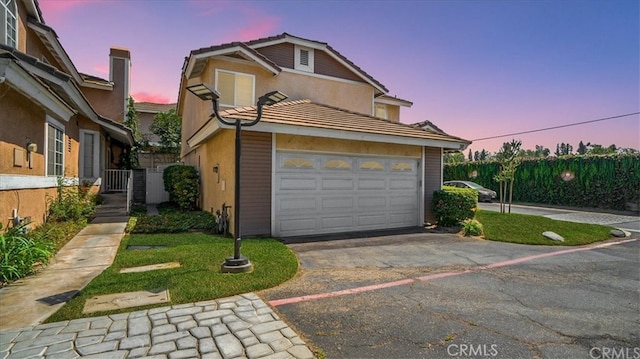 9900 Tagus St Unit 30, Pico Rivera, CA 90660 - view of front of house featuring driveway, stucco siding, a tiled roof, and an attached garage