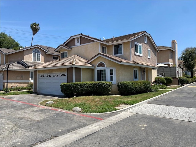 9900 Tagus St Unit 30, Pico Rivera, CA 90660 - view of front of house featuring stucco siding, an attached garage, and driveway
