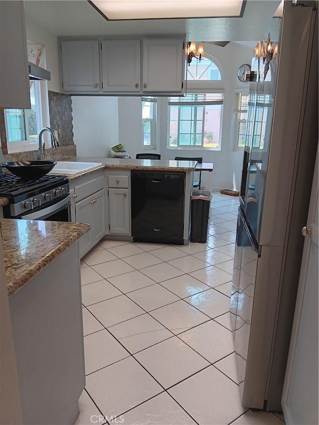 9900 Tagus St Unit 30, Pico Rivera, CA 90660 - kitchen with black dishwasher, stainless steel range with gas cooktop, a chandelier, light tile patterned floors, and freestanding refrigerator