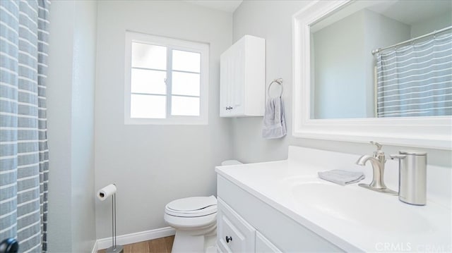 9900 Tagus St Unit 30, Pico Rivera, CA 90660 - full bathroom with toilet, vanity, wood finished floors, and baseboards