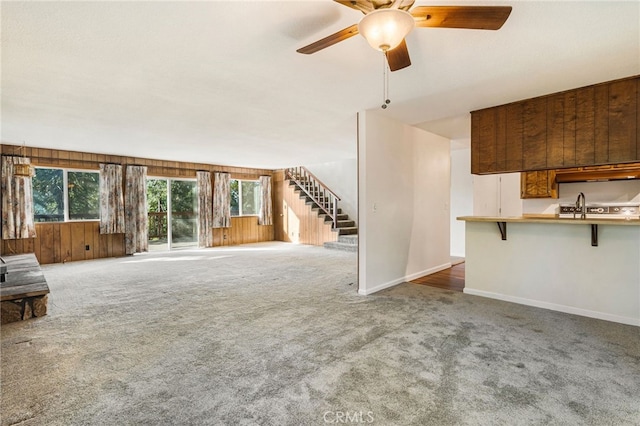 64 Rebie Way, Oroville, CA 95966 - unfurnished living room with carpet, stairs, ceiling fan, baseboards, and wooden walls