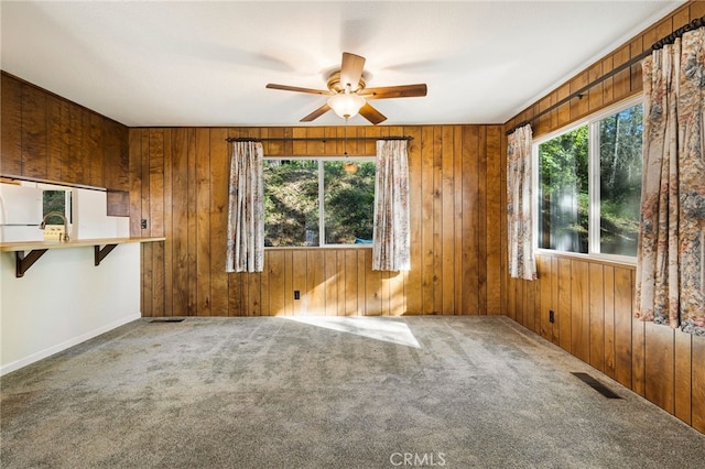 64 Rebie Way, Oroville, CA 95966 - unfurnished living room featuring a ceiling fan, plenty of natural light, carpet, and wooden walls