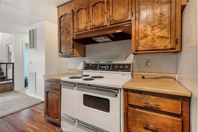 64 Rebie Way, Oroville, CA 95966 - kitchen featuring white range with electric cooktop, under cabinet range hood, dark wood-style flooring, and brown cabinetry