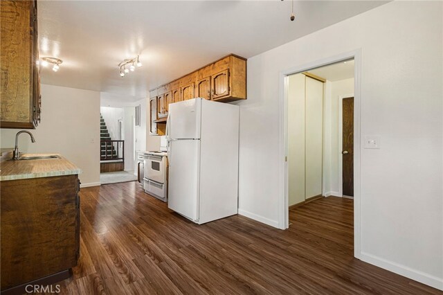 64 Rebie Way, Oroville, CA 95966 - kitchen featuring white appliances, a sink, dark wood-type flooring, baseboards, and light countertops