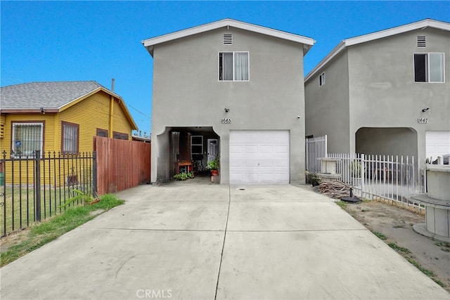 1665 E 84th St, Los Angeles, CA 90001 - back of house with stucco siding, an attached garage, and driveway