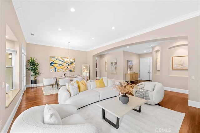 7064 Isle Ct, Rancho Cucamonga, CA 91739 - living room featuring baseboards, a chandelier, wood finished floors, arched walkways, and crown molding