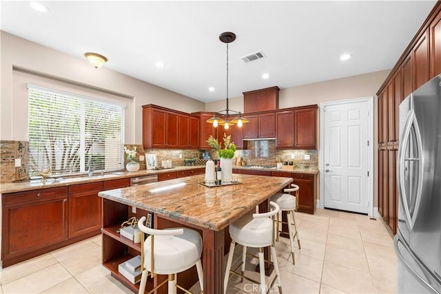 7064 Isle Ct, Rancho Cucamonga, CA 91739 - kitchen with stainless steel appliances, a center island, decorative backsplash, light tile patterned floors, and recessed lighting