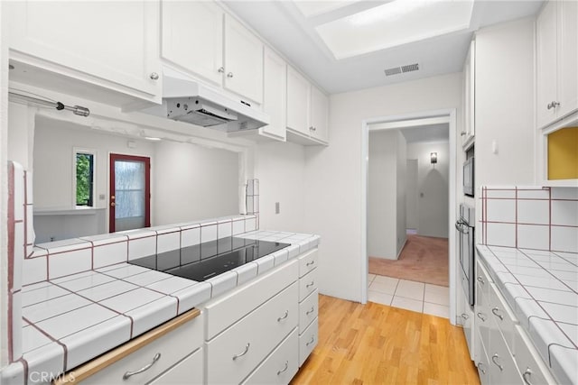 8950 Pueblo Ave, Atascadero, CA 93422 - kitchen featuring tile countertops, stainless steel appliances, under cabinet range hood, and white cabinets