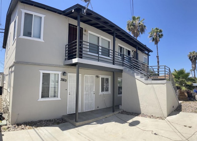 386771 Menlo Ave, San Diego, CA 92105 - rear view of property with stucco siding and a balcony