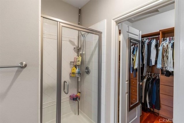 23402 Brookdale Ln Unit 56, Valencia, CA 91355 - bathroom featuring a spacious closet, a shower stall, and wood finished floors