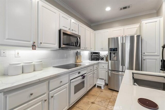 23402 Brookdale Ln Unit 56, Valencia, CA 91355 - kitchen featuring stainless steel appliances, white cabinetry, tasteful backsplash, ornamental molding, and light stone countertops
