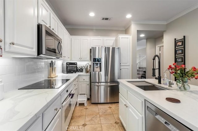 23402 Brookdale Ln Unit 56, Valencia, CA 91355 - kitchen featuring stainless steel appliances, white cabinetry, ornamental molding, backsplash, and recessed lighting