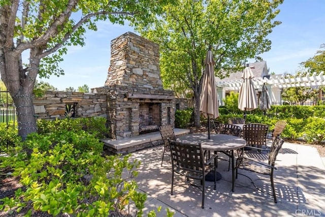 23402 Brookdale Ln Unit 56, Valencia, CA 91355 - view of patio / terrace featuring an outdoor stone fireplace, outdoor dining space, and a pergola
