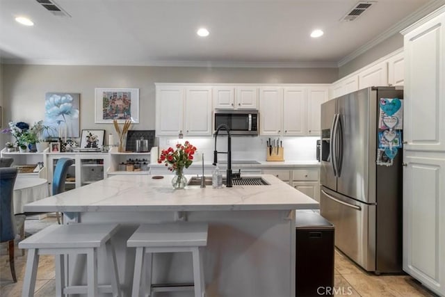 23402 Brookdale Ln Unit 56, Valencia, CA 91355 - kitchen featuring appliances with stainless steel finishes, white cabinetry, ornamental molding, light stone countertops, and a breakfast bar