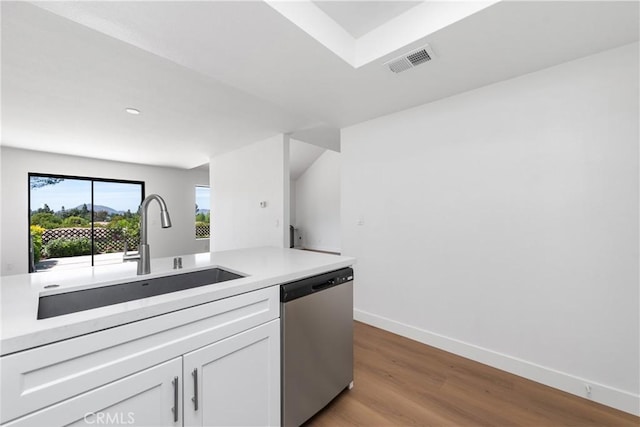 659 Valley Oak Ln, Newbury Park, CA 91320 - kitchen with stainless steel dishwasher, a sink, white cabinetry, light wood-type flooring, and light countertops