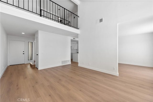 659 Valley Oak Ln, Newbury Park, CA 91320 - unfurnished living room featuring a high ceiling, baseboards, wood finished floors, and recessed lighting