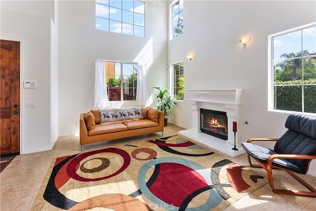 7659 Balasiano Ave, West Hills, CA 91304 - living area featuring a towering ceiling, a glass covered fireplace, and baseboards