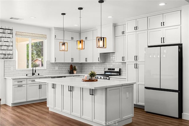 5755 Fickett Ln, Paradise, CA 95969 - kitchen featuring stainless steel appliances, a sink, a center island, dark wood-type flooring, and tasteful backsplash