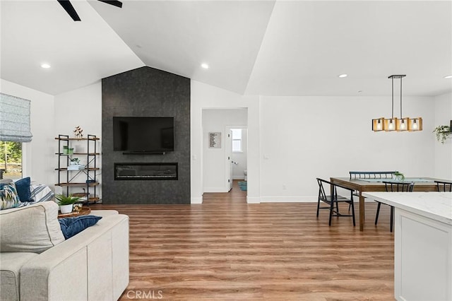 5755 Fickett Ln, Paradise, CA 95969 - living room with light wood finished floors, vaulted ceiling, a tiled fireplace, a ceiling fan, and recessed lighting