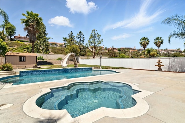 25 Del Brienza, Lake Elsinore, CA 92532 - view of swimming pool featuring a water slide, a fenced backyard, a patio, an outdoor structure, and an in-ground hot tub