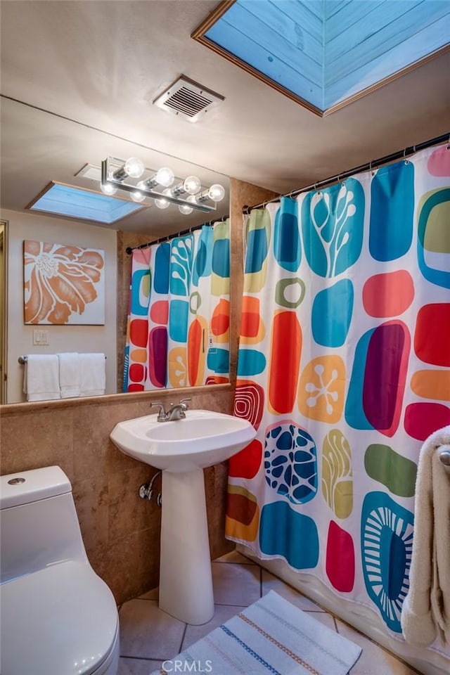 576 E Desert Holly Cir, Palm Springs, CA 92262 - bathroom featuring toilet, tile patterned floors, a shower with curtain, and tile walls