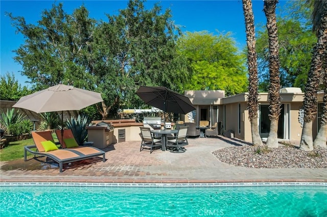 576 E Desert Holly Cir, Palm Springs, CA 92262 - swimming pool with exterior kitchen, a patio area, and outdoor dining space