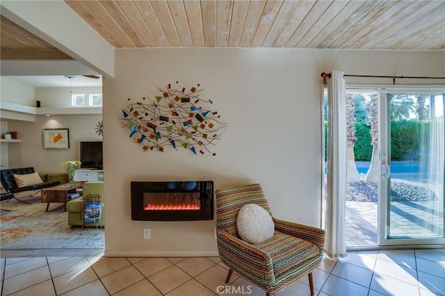 576 E Desert Holly Cir, Palm Springs, CA 92262 - living area featuring wooden ceiling, tile patterned flooring, a glass covered fireplace, and baseboards