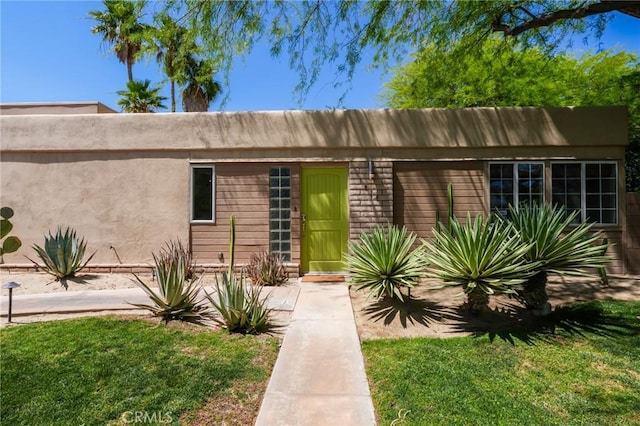 576 E Desert Holly Cir, Palm Springs, CA 92262 - view of front of home featuring a front yard and stucco siding