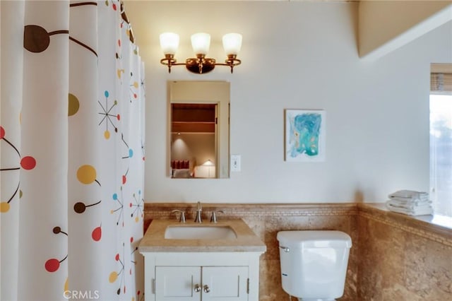 576 E Desert Holly Cir, Palm Springs, CA 92262 - full bath featuring vanity, toilet, tile walls, a shower with curtain, and a wainscoted wall