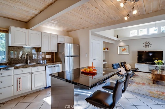 576 E Desert Holly Cir, Palm Springs, CA 92262 - kitchen with a sink, stainless steel appliances, wood ceiling with exposed beams, light tile patterned floors, and decorative backsplash