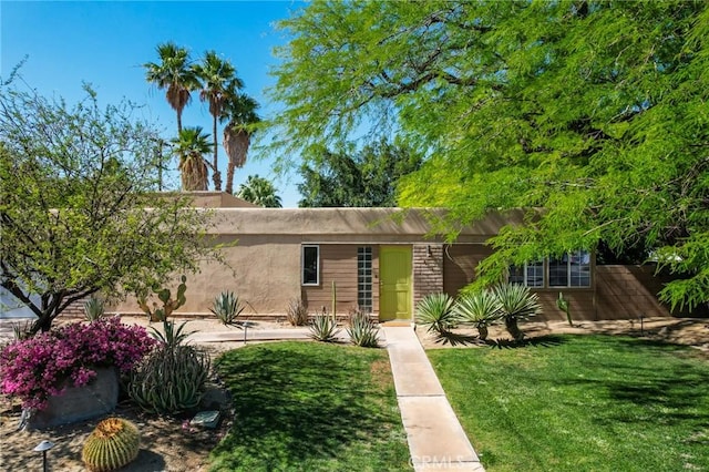576 E Desert Holly Cir, Palm Springs, CA 92262 - view of front facade with a front yard and stucco siding