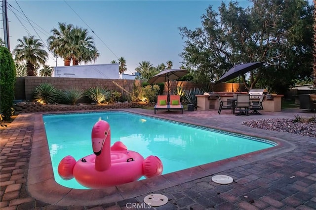 576 E Desert Holly Cir, Palm Springs, CA 92262 - view of pool with an outdoor kitchen, a fenced backyard, and a patio