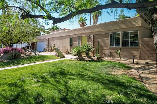 576 E Desert Holly Cir, Palm Springs, CA 92262 - view of front of property featuring an attached garage, a front yard, and stucco siding