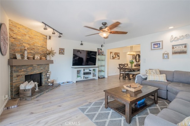 16732 Lassen St, Northridge, CA 91343 - living room with a ceiling fan, wood finished floors, track lighting, and a stone fireplace