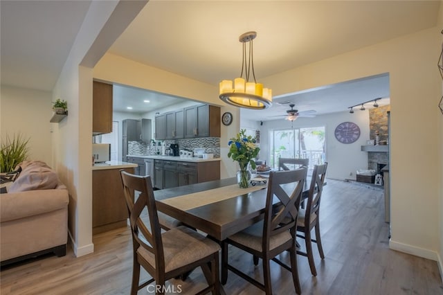16732 Lassen St, Northridge, CA 91343 - dining area with a ceiling fan, light wood finished floors, baseboards, a chandelier, and a fireplace