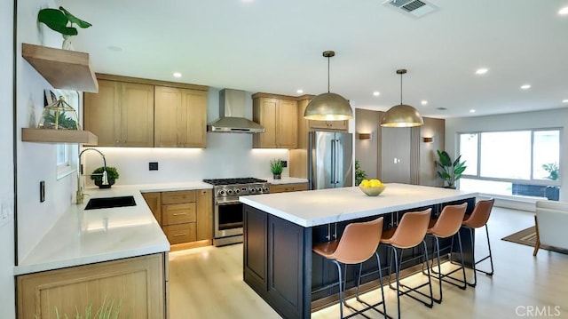 2737 Lorenzo Ave, Costa Mesa, CA 92626 - kitchen with stainless steel appliances, wall chimney range hood, a sink, a kitchen island, and a kitchen bar
