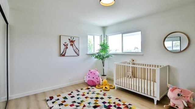 2737 Lorenzo Ave, Costa Mesa, CA 92626 - bedroom with wood finished floors, a nursery area, and baseboards