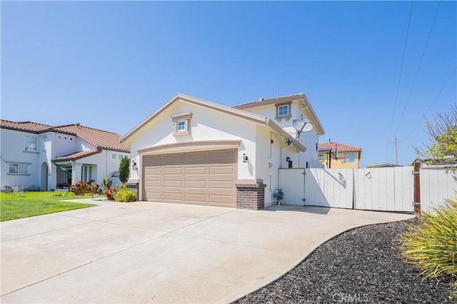 429 Tudor Way, Salinas, CA 93906 - mediterranean / spanish house featuring a gate, concrete driveway, stucco siding, an attached garage, and brick siding