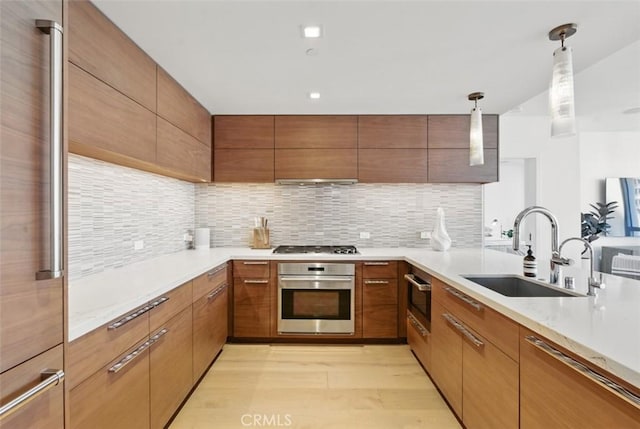 888 W E St Unit 505, San Diego, CA 92101 - kitchen featuring stainless steel appliances, a sink, backsplash, and pendant lighting