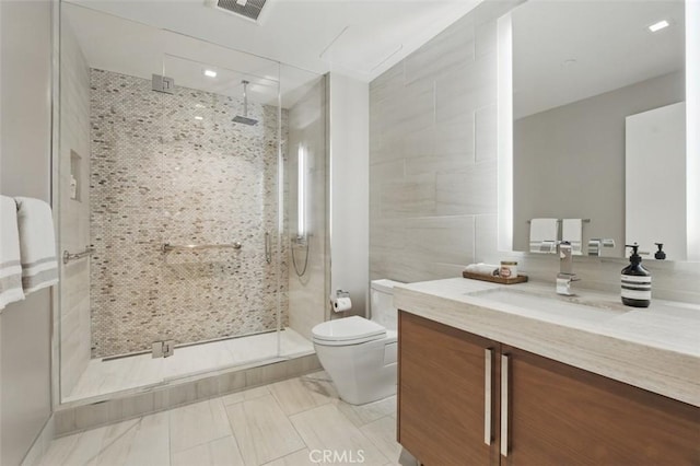 888 W E St Unit 505, San Diego, CA 92101 - bathroom featuring toilet, vanity, a stall shower, and tile walls