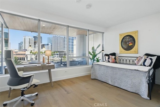 888 W E St Unit 505, San Diego, CA 92101 - bedroom featuring a skyline view, wood finished floors, and baseboards
