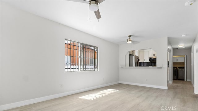 413 E 81st St, Los Angeles, CA 90003 - unfurnished living room featuring ceiling fan, washing machine and clothes dryer, light wood-type flooring, and baseboards